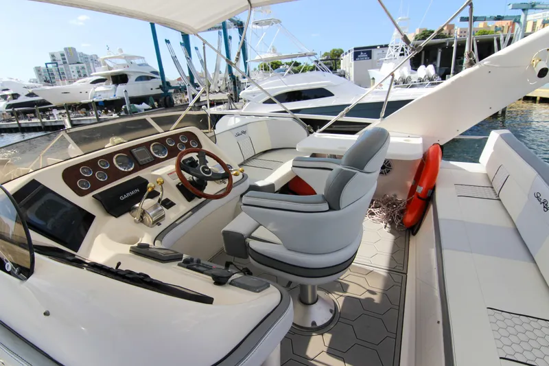 Pal'party Yacht Photos Pics 2000 Sea Ray 450 Express Bridge yacht cockpit with steering wheel and seating at marina.