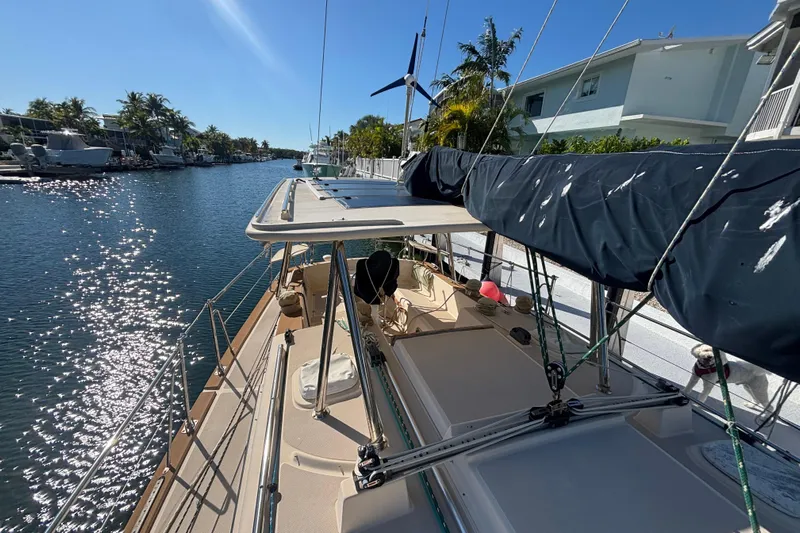 Inspiration Yacht Photos Pics 1989 Island Packet 38 sailboat docked in sunny canal, surrounded by palm trees.