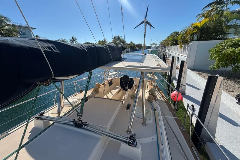 Inspiration Yacht Photos Pics 1989 Island Packet 38 sailboat docked, featuring a covered deck and wind turbine.