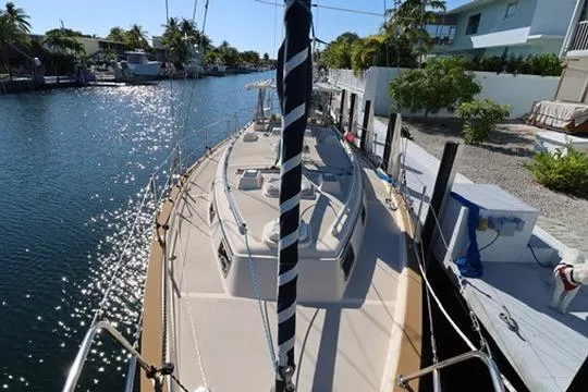 Inspiration Yacht Photos Pics 1989 Island Packet 38 sailboat docked in sunny canal, surrounded by palm trees.