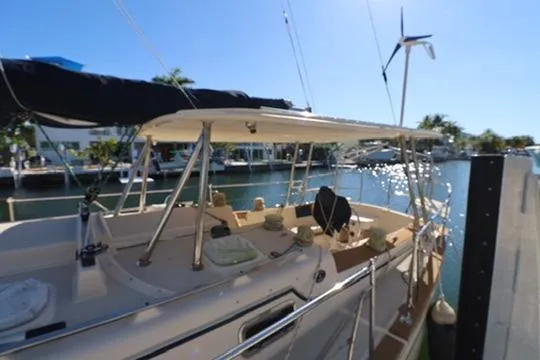 Inspiration Yacht Photos Pics 1989 Island Packet 38 sailboat docked in sunny marina, featuring spacious deck and canopy.