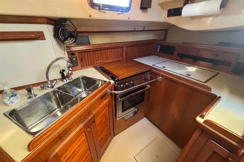 Inspiration Yacht Photos Pics 1989 Island Packet 38 yacht kitchen with dual sinks, stove, and wooden cabinetry.