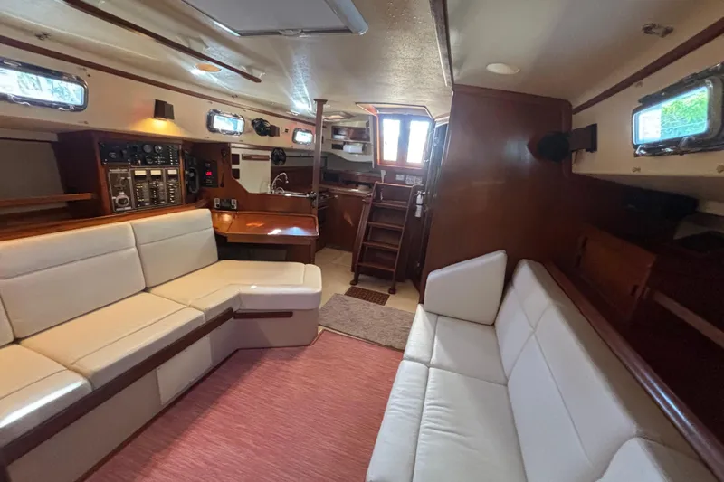 Inspiration Yacht Photos Pics Interior of 1989 Island Packet 38 sailboat with white seating and wooden accents.