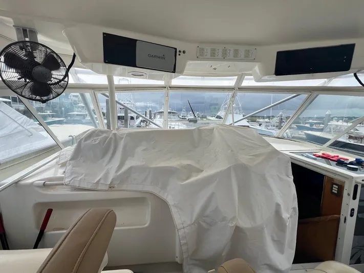 Short People Yacht Photos Pics Interior view of 1999 Ocean Yachts EXPRESS boat cockpit with covered controls and marina background.