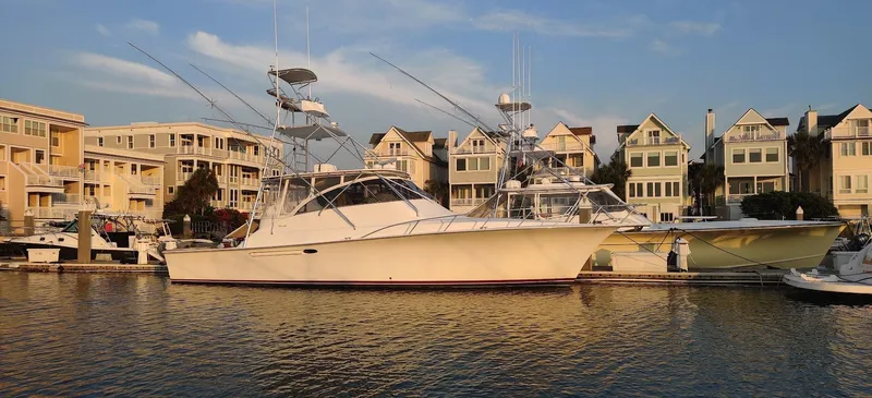 Short People Yacht Photos Pics 1999 Ocean Yachts EXPRESS docked near waterfront homes, under a clear sky.