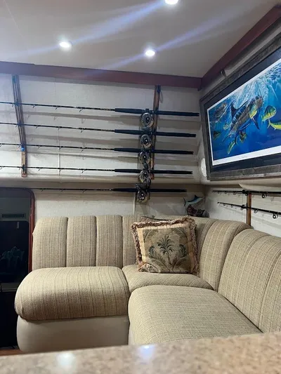 Short People Yacht Photos Pics 1999 Ocean Yachts EXPRESS interior with fishing rods and cozy seating area.