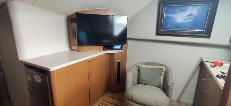 Short People Yacht Photos Pics Interior of 1999 Ocean Yachts EXPRESS with TV, chair, and framed artwork.