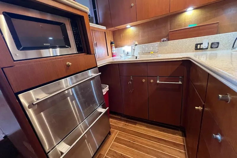 Short People Yacht Photos Pics 1999 Ocean Yachts EXPRESS SPORTFISH 800 CAT's kitchen with wood cabinetry and stainless steel appliances.