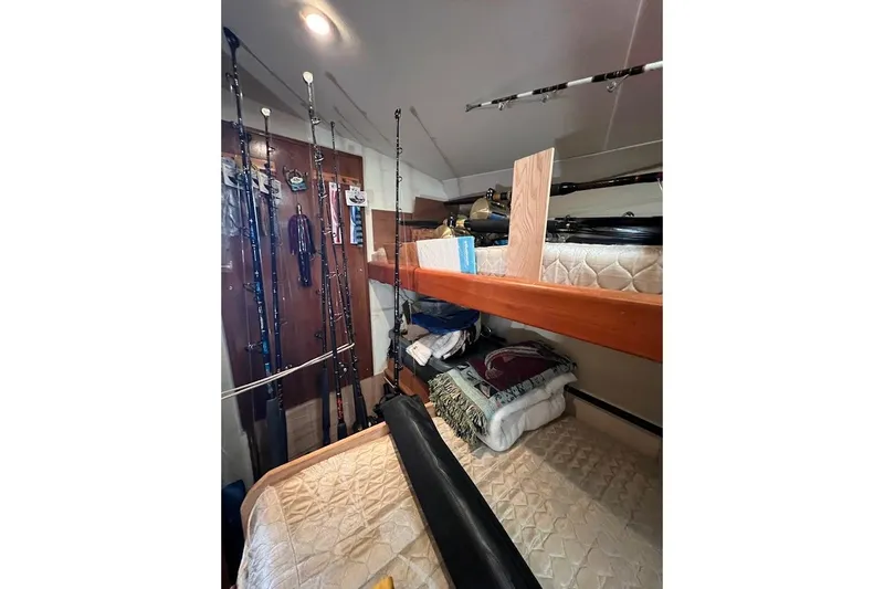 Short People Yacht Photos Pics 1999 Ocean Yachts EXPRESS SPORTFISH 800 CAT's interior with fishing rods and bunk beds.