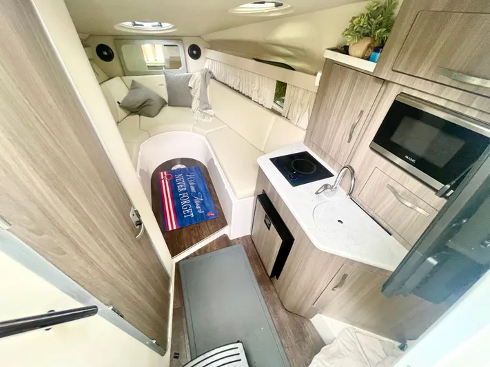  Yacht Photos Pics Interior of 2019 Regal 28 Express boat with kitchenette and seating area.