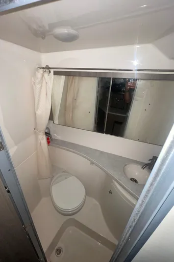  Yacht Photos Pics 2019 Regal 28 Express boat bathroom with toilet, sink, and mirror.