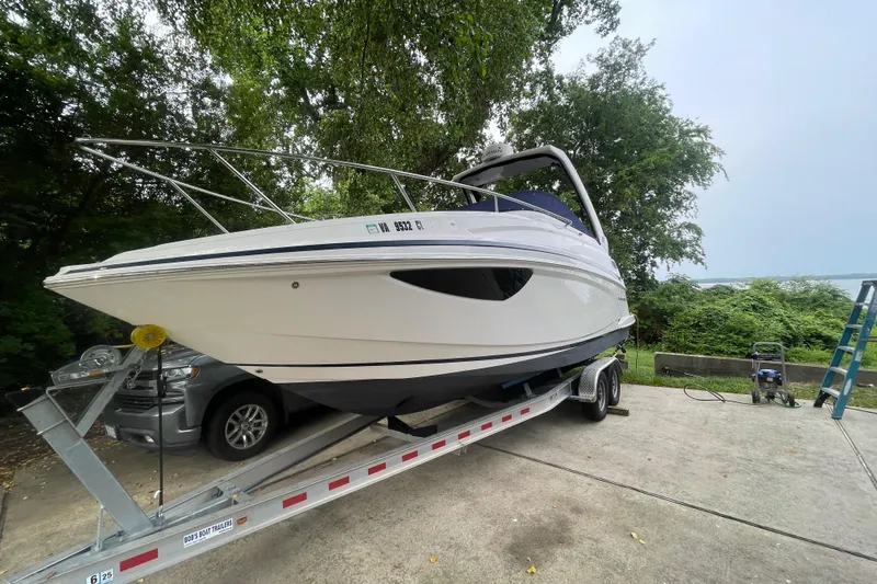  Yacht Photos Pics 2019 Regal 28 Express boat on trailer, parked outdoors near trees.