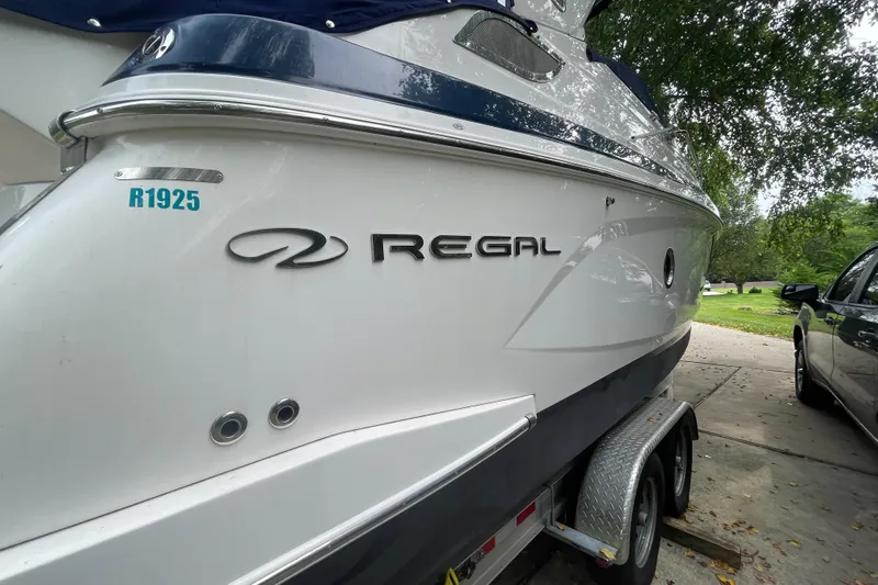  Yacht Photos Pics 2019 Regal 28 Express boat on trailer, parked outdoors.