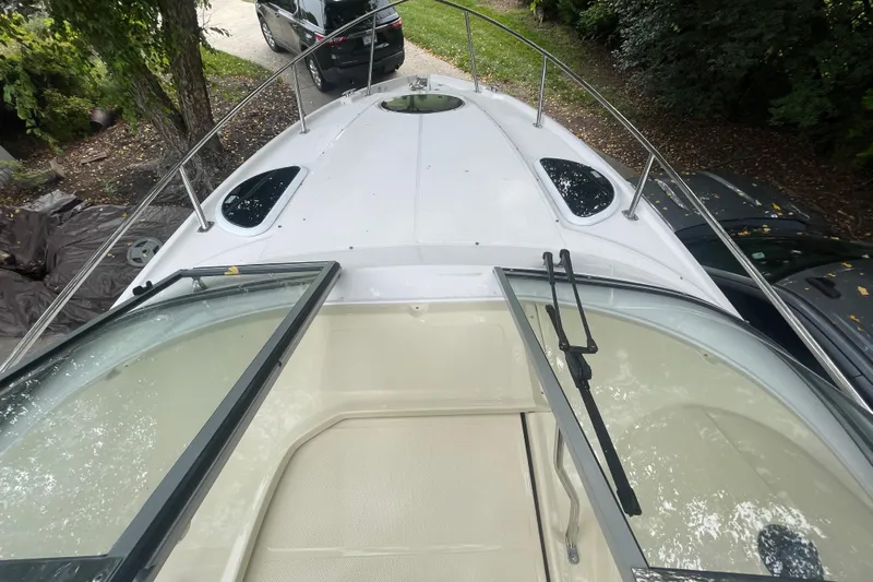  Yacht Photos Pics 2019 Regal 28 Express boat deck with open windshield, surrounded by trees and parked cars.