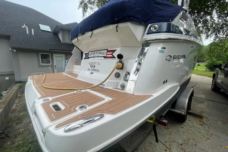  Yacht Photos Pics 2019 Regal 28 Express boat on trailer, parked near a house.