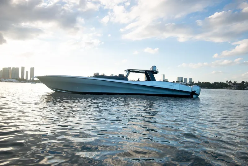  Yacht Photos Pics 2025 Sardine Marine Custom Race 55 boat on calm water, city skyline in background.