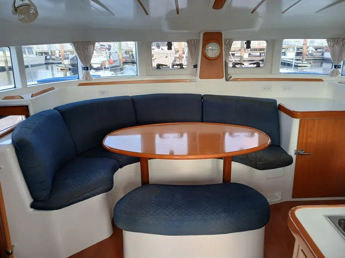 Double Diamond Yacht Photos Pics Interior of 2007 Lagoon 380 S2 catamaran with curved seating and wooden table.