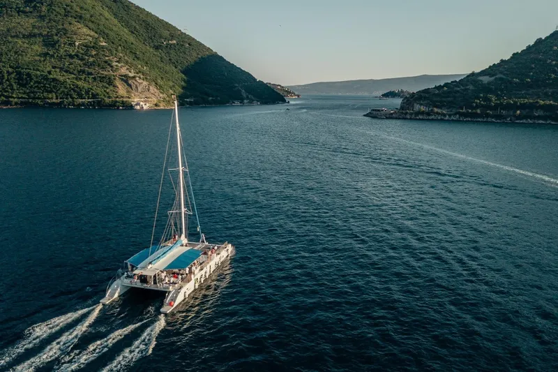 Tahiti Yacht Photos Pics Aerial view of 2015 Fountaine Pajot TAHITI catamaran sailing between lush green hills.