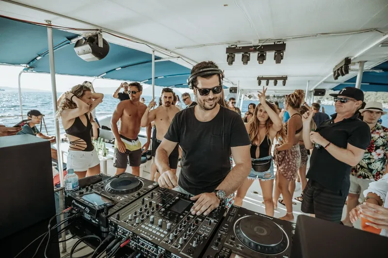 Tahiti Yacht Photos Pics DJ playing music on a 2015 Fountaine Pajot TAHITI catamaran party with dancing crowd.