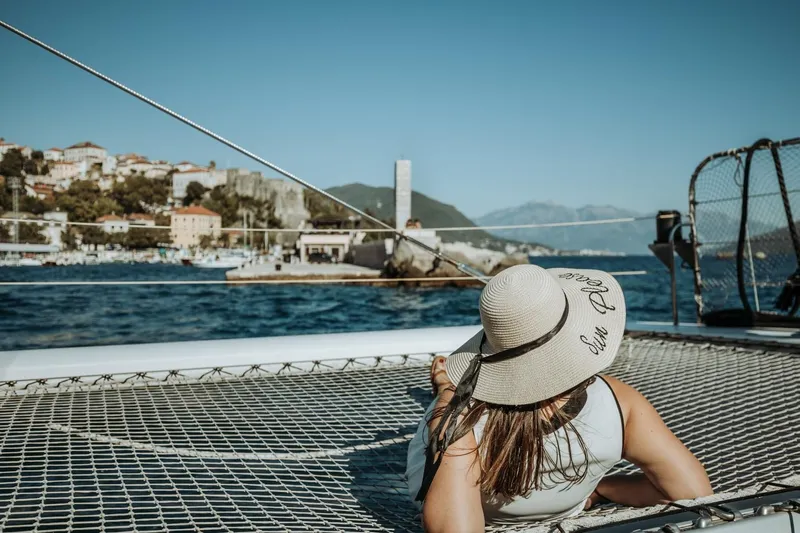 Tahiti Yacht Photos Pics Woman relaxing on 2015 Fountaine Pajot TAHITI catamaran, scenic coastal view.