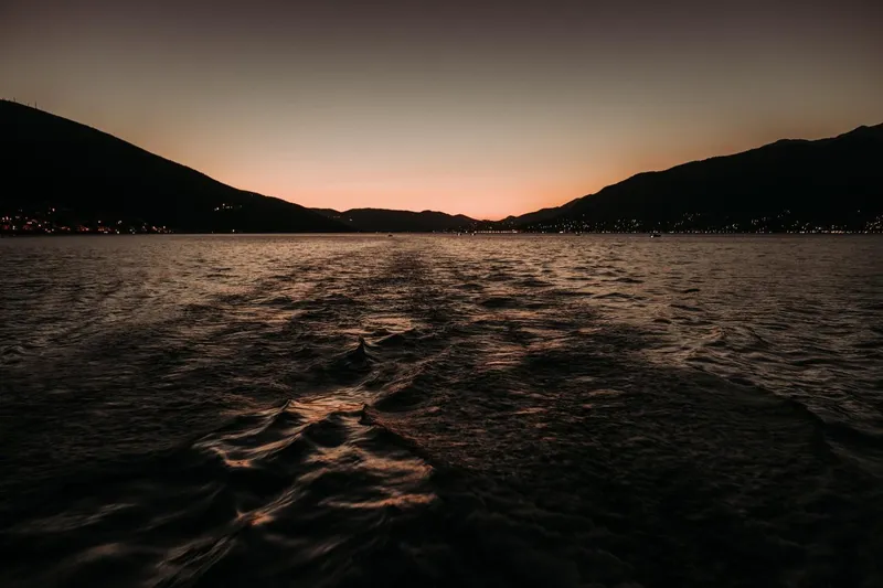 Tahiti Yacht Photos Pics Sunset view from a 2015 Fountaine Pajot TAHITI, with serene waters and silhouetted hills.