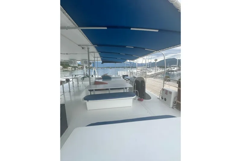 Tahiti Yacht Photos Pics Spacious deck of 2015 Fountaine Pajot TAHITI catamaran with blue canopy and seating.