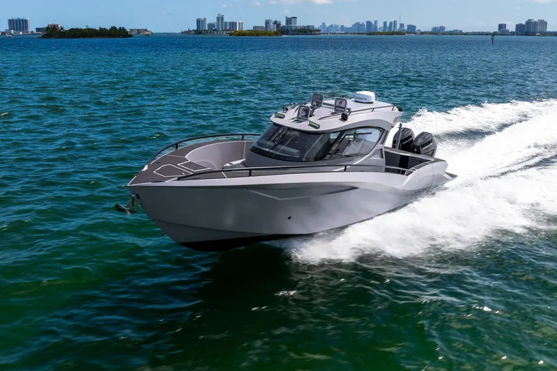  Yacht Photos Pics Sleek Novielli SERE 2025 boat cruising on blue ocean waters near city skyline.