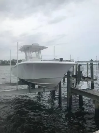  Yacht Photos Pics 2020 Invincible 33 Open Fisherman boat docked on a lift by the water.