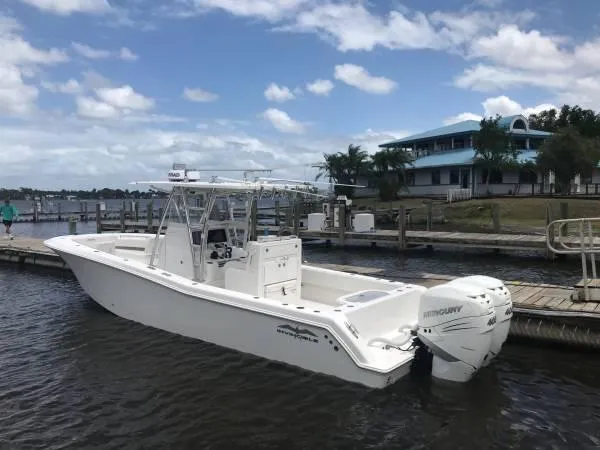  Yacht Photos Pics 2020 Invincible 33 Open Fisherman boat docked by a scenic waterfront.
