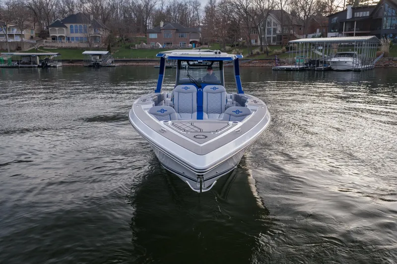  Yacht Photos Pics 2026 Fountain 38 SCX boat on a calm lake near waterfront homes.