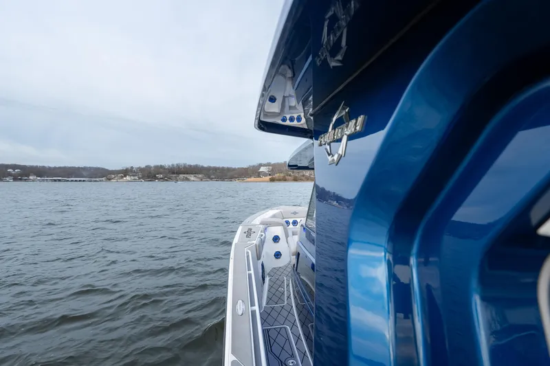  Yacht Photos Pics 2026 Fountain 38 SCX boat on water, showcasing sleek blue design and spacious deck.