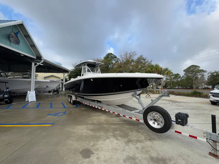  Yacht Photos Pics 2018 Fountain 34 CC boat on trailer at dealership, cloudy sky background.