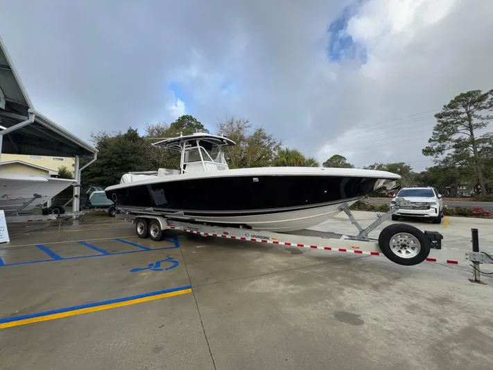  Yacht Photos Pics 2018 Fountain 34 CC boat on trailer in parking lot, overcast sky.