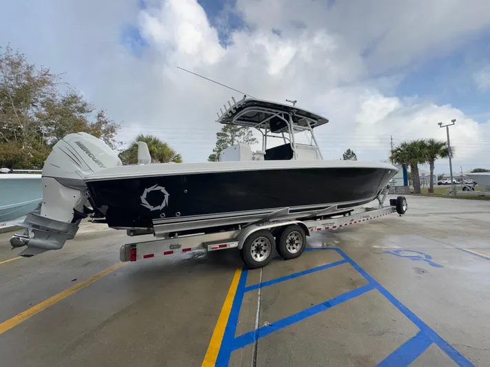  Yacht Photos Pics 2018 Fountain 34 CC boat on trailer in parking lot, cloudy sky background.