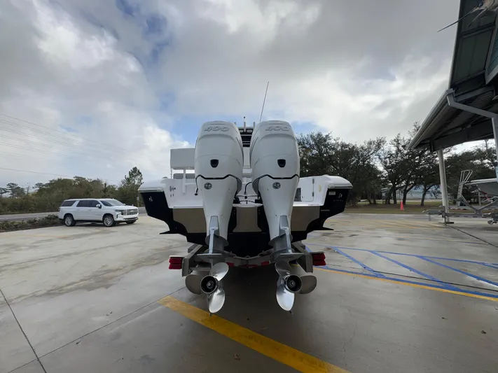 Yacht Photos Pics 2018 Fountain 34 CC boat with dual outboard motors in a parking area.