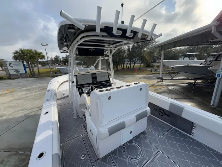  Yacht Photos Pics 2018 Fountain 34 CC boat with modern console and seating, docked outdoors.