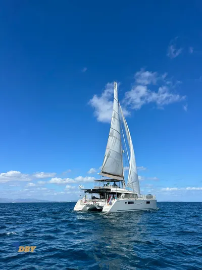 Samadhi Yacht Photos Pics 2019 Lagoon 560 S2 catamaran sailing on open sea under clear blue sky.