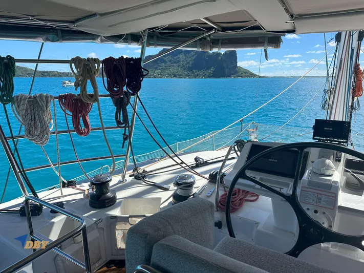 Samadhi Yacht Photos Pics Cockpit view of 2019 Lagoon 560 S2 yacht with ocean and island backdrop.