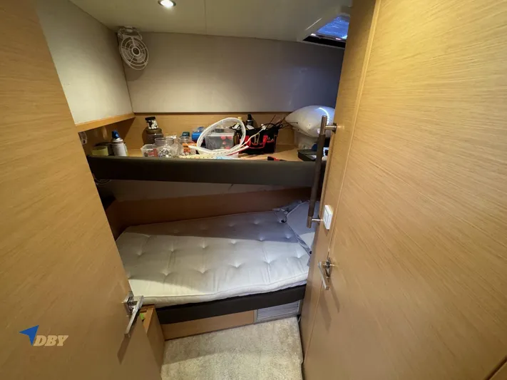Samadhi Yacht Photos Pics Small cabin interior of 2019 Lagoon 560 S2 yacht with bunk bed and storage shelves.