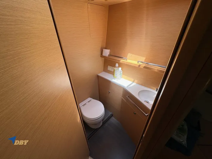 Samadhi Yacht Photos Pics 2019 Lagoon 560 S2 yacht bathroom with wooden interior, toilet, and sink.