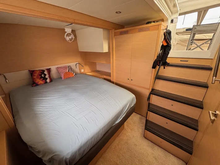 Samadhi Yacht Photos Pics Luxurious cabin interior of 2019 Lagoon 560 S2 yacht with cozy bed and wooden stairs.