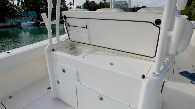  Yacht Photos Pics 2022 Cobia 350 Center Console boat with open storage compartment, docked by the water.