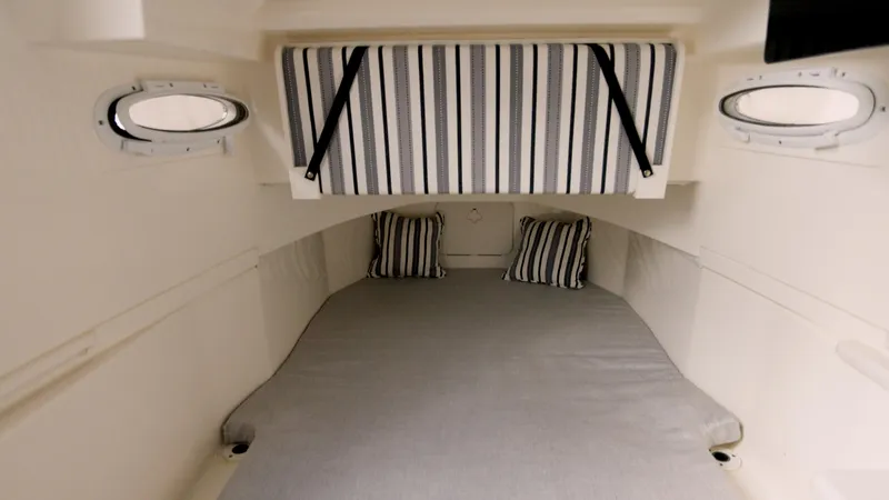  Yacht Photos Pics 2022 Cobia 350 Center Console cabin interior with striped cushions and portholes.