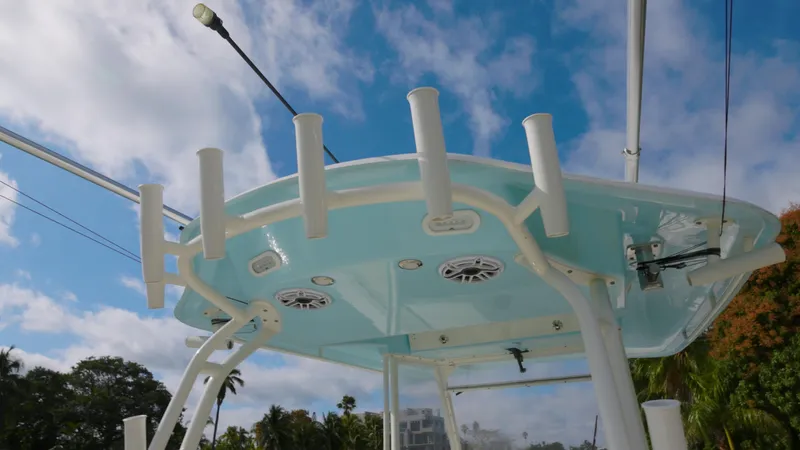  Yacht Photos Pics 2022 Cobia 350 Center Console boat with rod holders and speakers against a blue sky.
