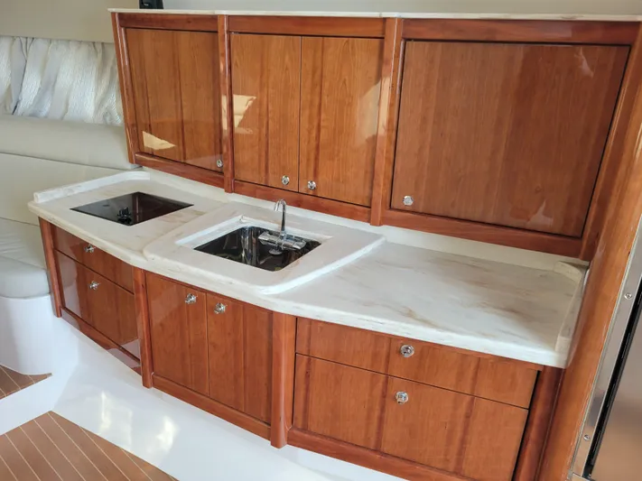  Yacht Photos Pics Luxurious wooden cabinetry and marble countertop in 2016 Intrepid 475 Sport Yacht kitchen.