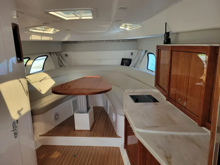  Yacht Photos Pics Interior of 2016 Intrepid 475 Sport Yacht with seating, table, and kitchenette.
