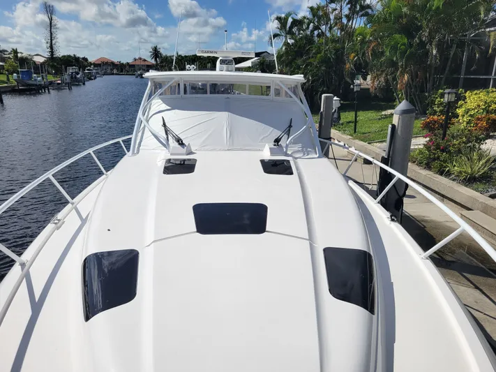  Yacht Photos Pics 2016 Intrepid 475 Sport Yacht docked by a scenic canal with lush greenery.