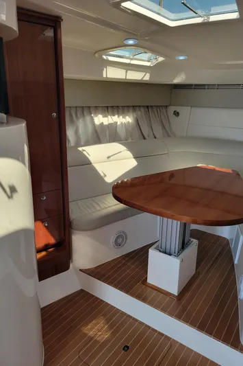  Yacht Photos Pics Interior of 2016 Intrepid 475 Sport Yacht with wooden table and white seating.