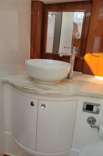  Yacht Photos Pics Luxurious bathroom interior of 2016 Intrepid 475 Sport Yacht with modern sink and wood accents.
