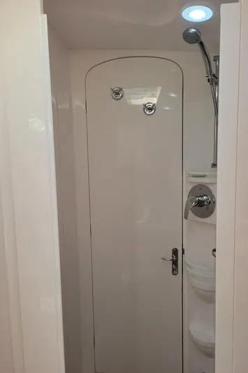  Yacht Photos Pics Shower area inside 2016 Intrepid 475 Sport Yacht, featuring sleek white design and modern fixtures.